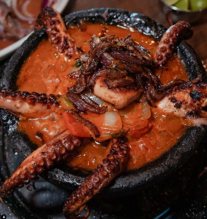 Pulpo molcajete bubbling in red salsa